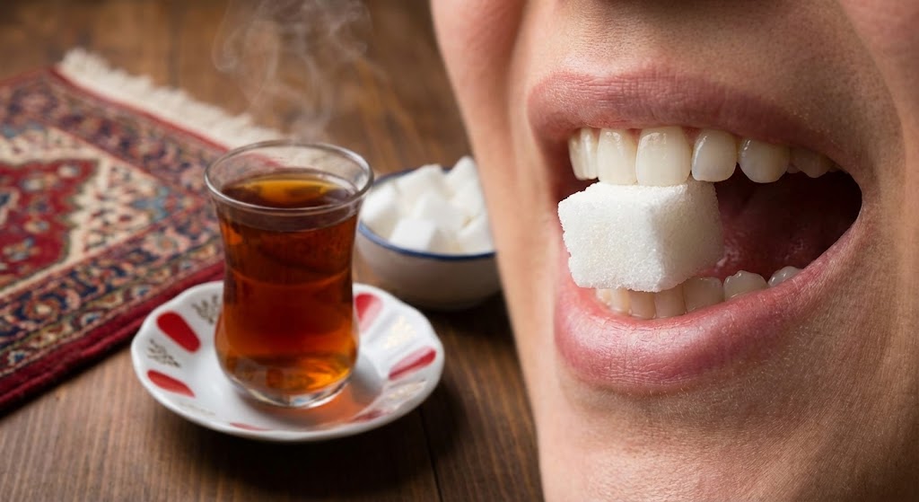 white sugar cube held between teeth Persian ghand pahlou tea ritual